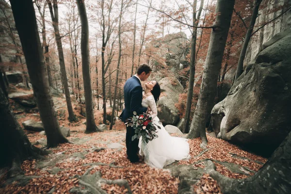 Чудова наречена, наречений цілується і обіймається біля скель з приголомшливими видами — стокове фото