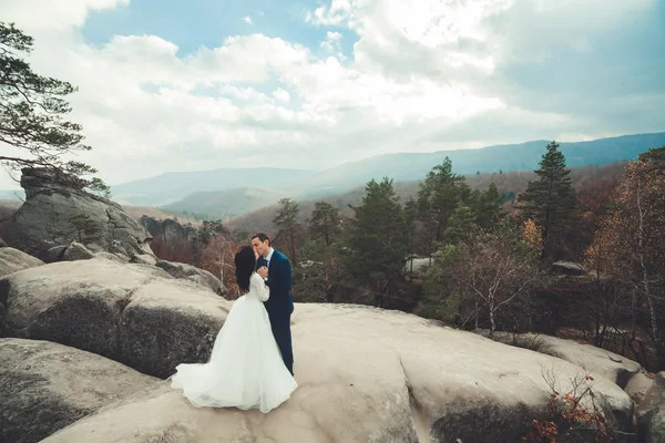 Splendida sposa, sposo baciare e abbracciare vicino alle scogliere con vista mozzafiato — Foto Stock