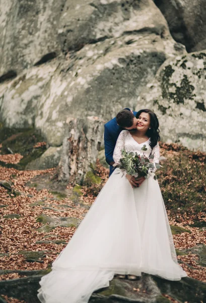 Splendida sposa, sposo baciare e abbracciare vicino alle scogliere con vista mozzafiato — Foto Stock