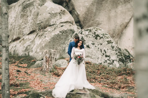 Preciosa novia, novio besándose y abrazándose cerca de los acantilados con impresionantes vistas —  Fotos de Stock