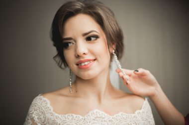 Beyaz elbiseli lüks gelin düğün törenine hazırlanırken poz veriyor.