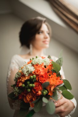 Beyaz elbiseli lüks gelin düğün törenine hazırlanırken poz veriyor.