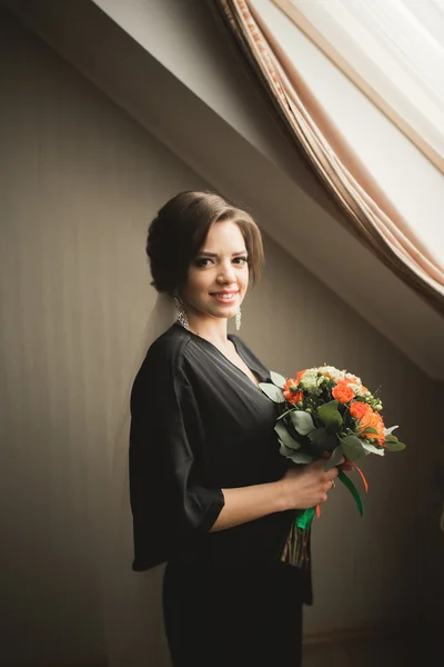 Noiva de luxo em roupão preto posando enquanto se prepara para a cerimônia de casamento — Fotografia de Stock