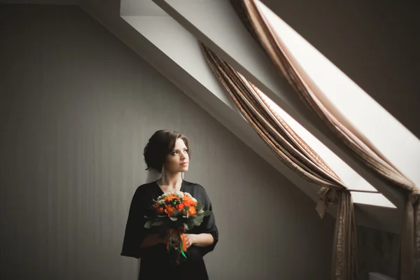 Noiva de luxo em roupão preto posando enquanto se prepara para a cerimônia de casamento — Fotografia de Stock