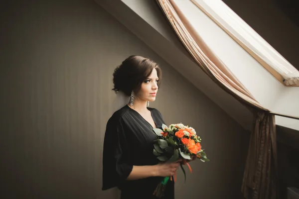 Luxusbraut in schwarzer Robe posiert während der Vorbereitungen für die Hochzeitszeremonie — Stockfoto