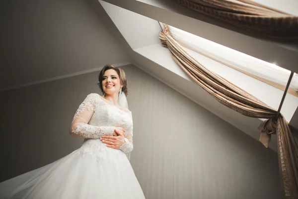 Noiva de luxo em vestido branco posando enquanto se prepara para a cerimônia de casamento — Fotografia de Stock