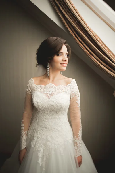 Novia de lujo en vestido blanco posando mientras se prepara para la ceremonia de boda — Foto de Stock