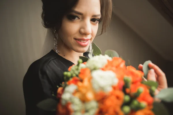 Noiva de luxo em roupão preto posando enquanto se prepara para a cerimônia de casamento — Fotografia de Stock