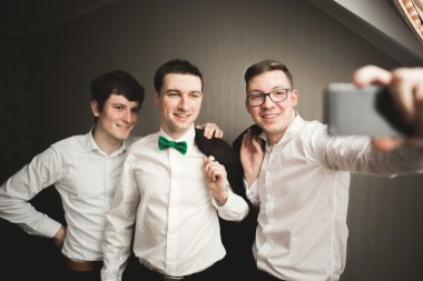 Mutlu arkadaş yardımcı olur şık damat onun düğün günü için hazırlanıyor