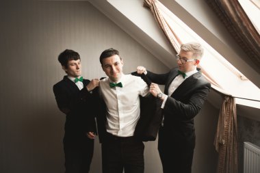 Mutlu arkadaş yardımcı olur şık damat onun düğün günü için hazırlanıyor