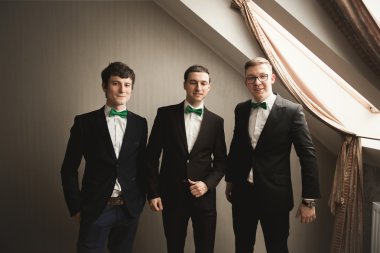 Mutlu arkadaş yardımcı olur şık damat onun düğün günü için hazırlanıyor