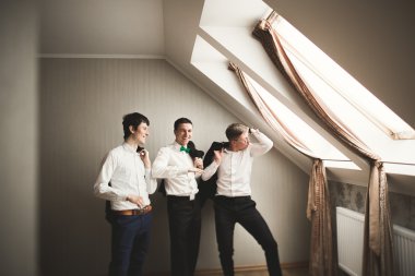 Mutlu arkadaş yardımcı olur şık damat onun düğün günü için hazırlanıyor