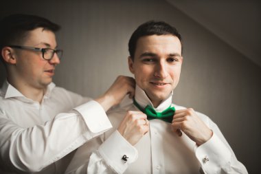 Mutlu arkadaş yardımcı olur şık damat onun düğün günü için hazırlanıyor