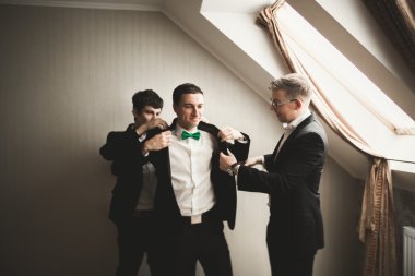 Mutlu arkadaş yardımcı olur şık damat onun düğün günü için hazırlanıyor