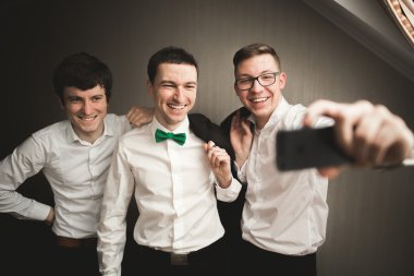 Mutlu arkadaş yardımcı olur şık damat onun düğün günü için hazırlanıyor