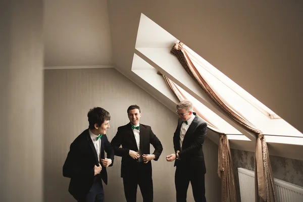 Amigos felizes ajuda o noivo elegante se preparando para seu dia do casamento — Fotografia de Stock