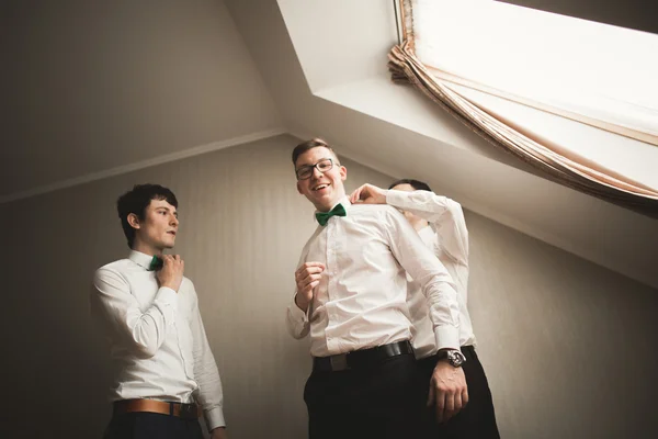 Щасливі друзі допомагають стильному нареченому готуватися до свого весілля — стокове фото