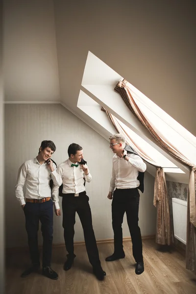 Amigos felizes ajuda o noivo elegante se preparando para seu dia do casamento — Fotografia de Stock