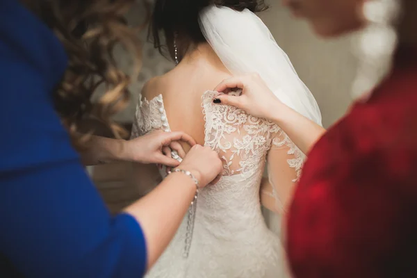 Amici felici aiuta la sposa a prepararsi per il giorno del suo matrimonio al mattino — Foto Stock