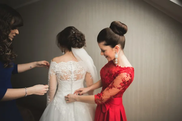 Gelukkig vrienden helpt bruid klaar voor haar trouwdag in de ochtend — Stockfoto