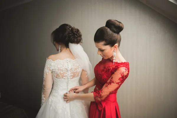 Amigos felizes ajuda noiva se preparando para o dia do casamento pela manhã — Fotografia de Stock