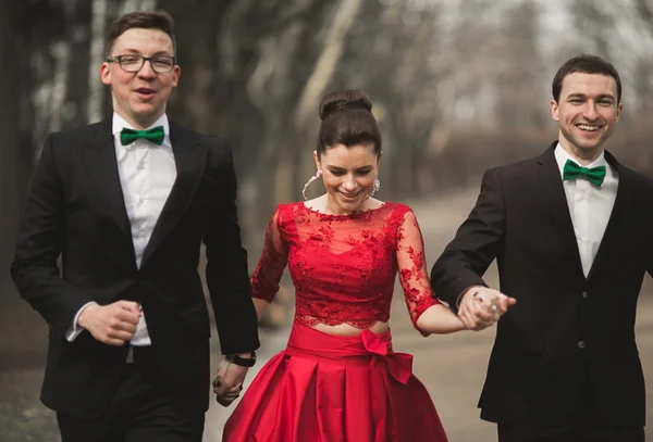 Dama de honra e padrinhos com casal de casamento posando no parque — Fotografia de Stock