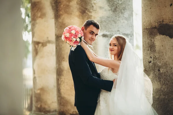 Pasangan pengantin baru yang romantis dan cantik berpelukan di dekat kastil tua — Stok Foto