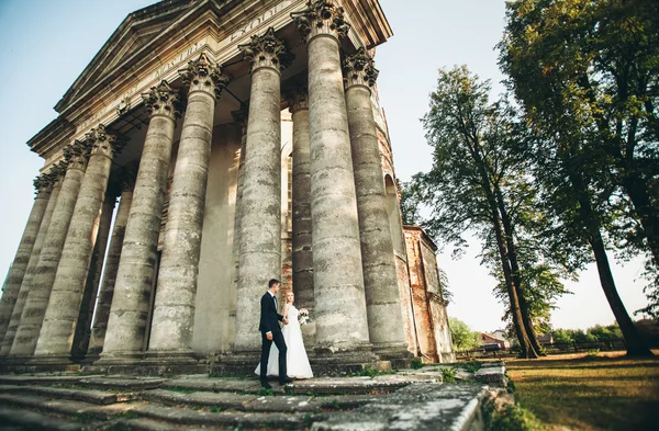 Piękny romantyczny ślub para nowożeńców przytulających się w pobliżu starego zamku — Zdjęcie stockowe