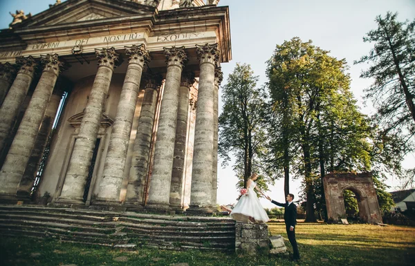 美しいロマンチックな結婚式のカップルの新婚旅行の近くに古い城抱擁 — ストック写真