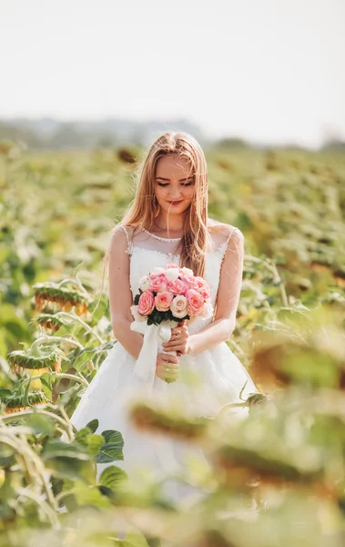 長い髪とフィールドのヒマワリの花束とエレガントな金髪の花嫁 — ストック写真