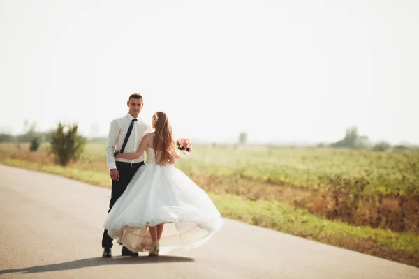 Schönes Hochzeitspaar, Braut und Bräutigam posiert auf der Straße — Stockfoto