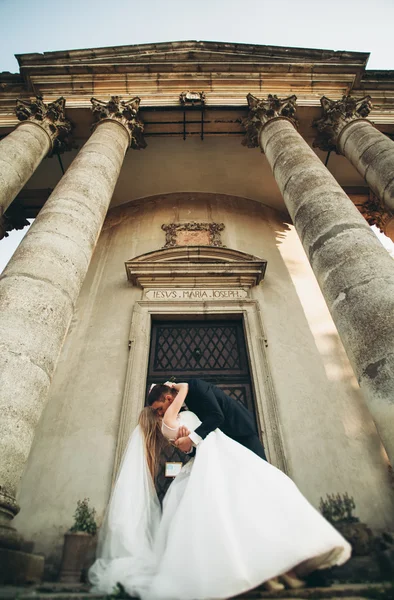 Güzel, romantik bir düğün. Yeni evliler. Eski kalenin yakınlarında sarılıyorlar. — Stok fotoğraf