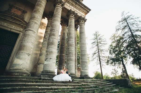 美しいロマンチックな結婚式のカップルの新婚旅行の近くに古い城抱擁 — ストック写真