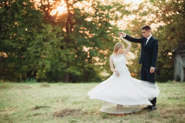 Casal romântico bonito do casamento, noivo e noiva abraçando perto do castelo velho no por do sol — Fotografia de Stock