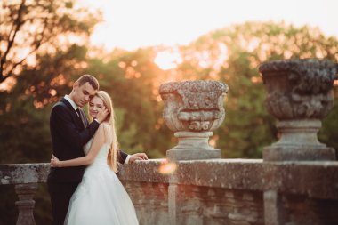 Güzel romantik Düğün çifti, damat ve gelin on sunset eski kale sarılma