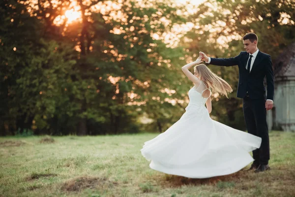 Vackra romantiska bröllop par, brudgummen och bruden kramas nära gamla slottet på sunset — Stockfoto