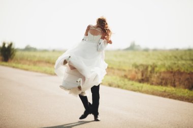 Güzel düğün çift, gelin ve damat yolda poz