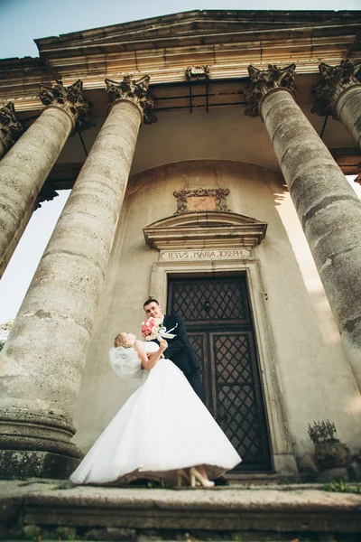 Bella coppia di sposi romantici che si abbracciano vicino al vecchio castello — Foto Stock