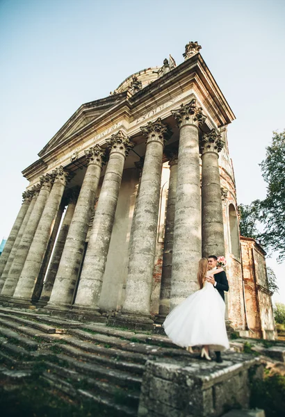 Beau couple de mariage romantique de jeunes mariés étreignant près du vieux château — Photo