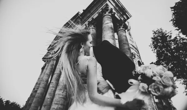 Beautiful romantic wedding couple of newlyweds hugging near old castle — Stock Photo, Image