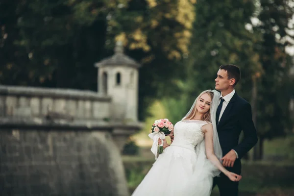 Hermosa boda romántica pareja de recién casados abrazos cerca del viejo castillo —  Fotos de Stock