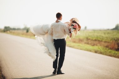 Güzel düğün çift, gelin ve damat yolda poz