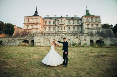 Güzel romantik Düğün çifti, damat ve gelin on sunset eski kale sarılma