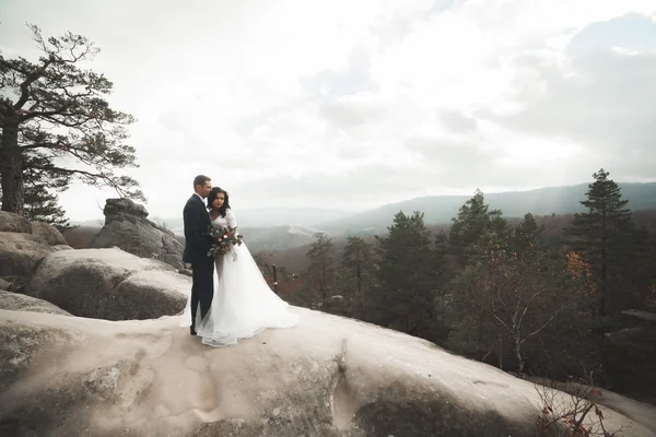 Чудова наречена, наречений цілується і обіймається біля скель з приголомшливими видами — стокове фото