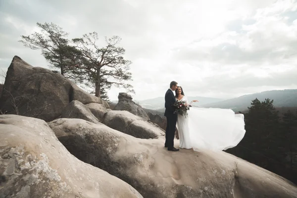 Prachtige bruid, bruidegom zoenen en knuffelen in de buurt van de kliffen met prachtig uitzicht — Stockfoto