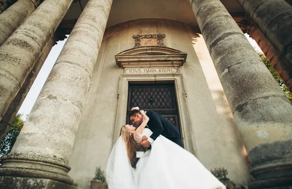 Beau couple de mariage romantique de jeunes mariés étreignant près du vieux château — Photo