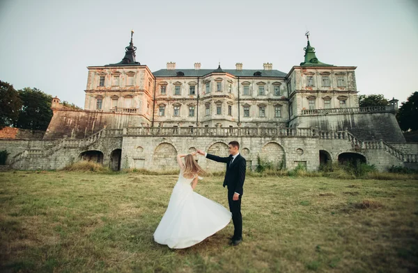 Beau couple de mariage romantique, marié et mariée étreignant près du vieux château au coucher du soleil — Photo