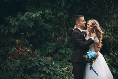 Sarılma ve öpüşme arka plan güzel bitkiler üzerinde lüks Düğün çifti mağara antik kale