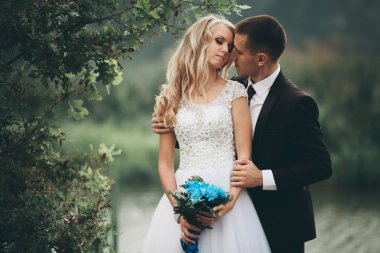 Romantik düğün çift karı güzel göl kenarında poz,