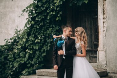 Mutlu düğün kaç sarılma ve birbirlerine arka plan güzel bitkiler kale üzerinde gülümseyen